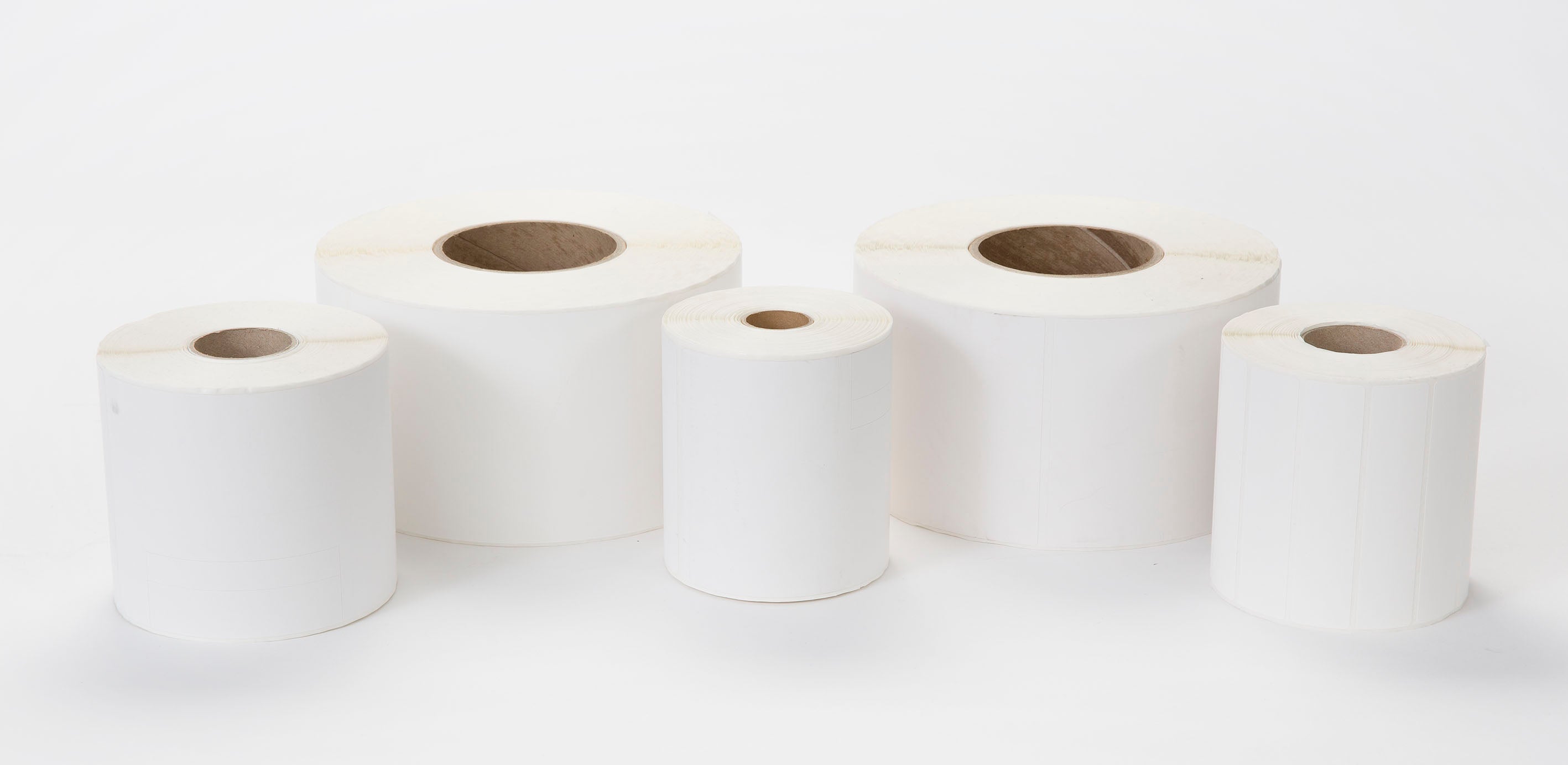 Varios rollos de etiquetas térmicas adhesivas SATO de diferentes tamaños sobre fondo blanco, ideales para trazabilidad y control alimentario en HORECA, cumpliendo APPCC y normativa de seguridad en hostelería, restauración y catering.